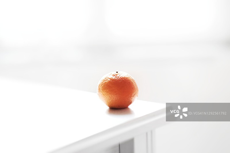 窗边白色橱柜上的橘子，清新概念图片素材