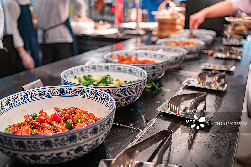 男人在自助餐中挑选四川美食图片素材