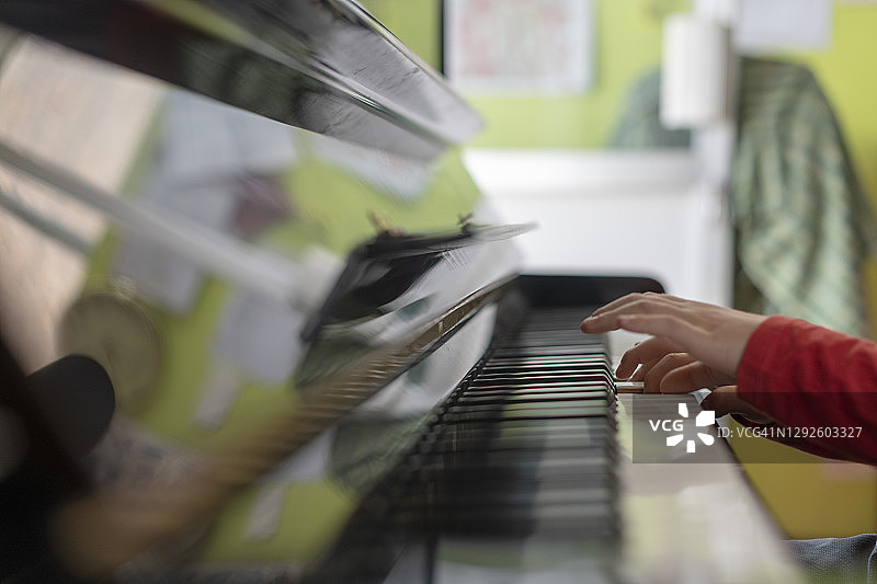 儿童在教室里弹钢琴特写图片素材