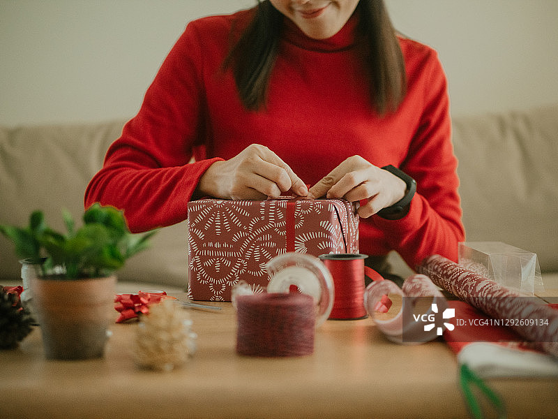 疫情期间，年轻亚洲女子在家包装圣诞礼物图片素材