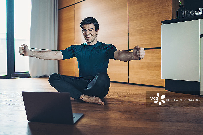 参加在线培训课程，伸展弹力带的运动员图片素材