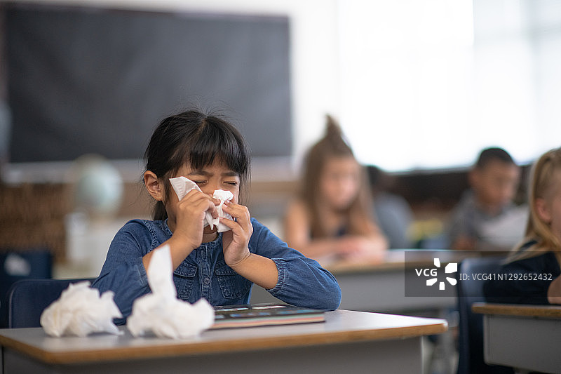 生病的学生在学校擤鼻涕图片素材