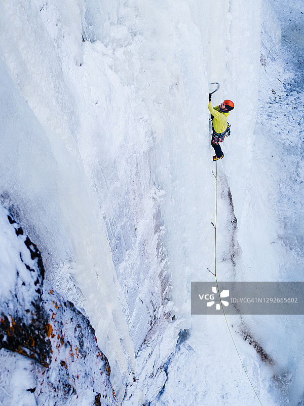 男子攀登BC省高耸垂直冰瀑的俯视图图片素材
