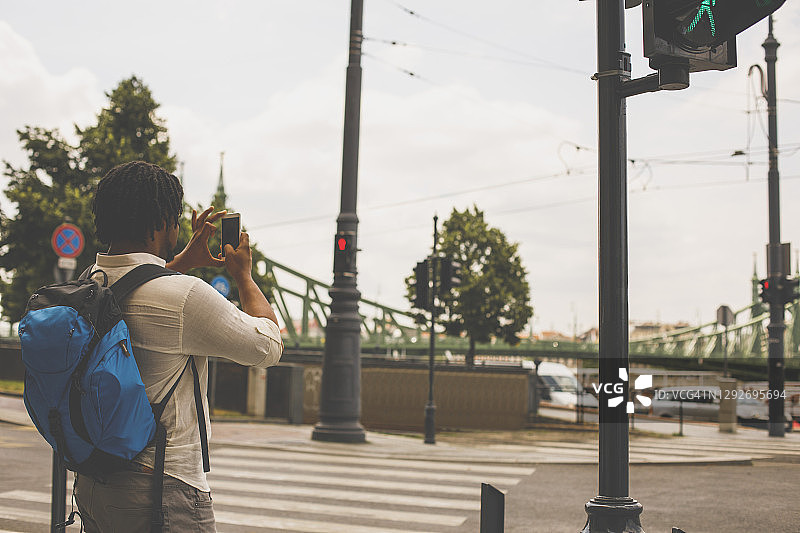 年轻男游客用智能手机拍照图片素材