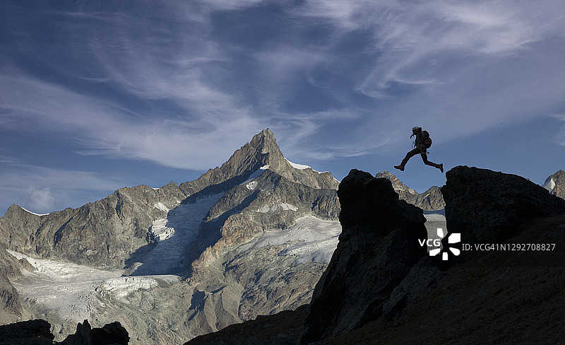 登山者在岩石间跳跃图片素材