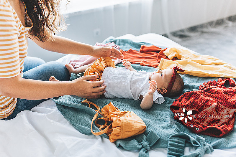 母亲在卧室里给儿子换衣服图片素材