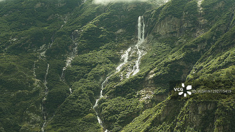 瑞士绿色岩石景观环绕的瀑布照片图片素材