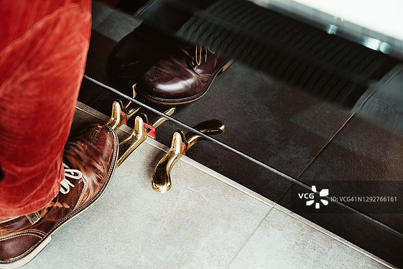 钢琴家演奏黑色钢琴踏板的脚部特写图片素材