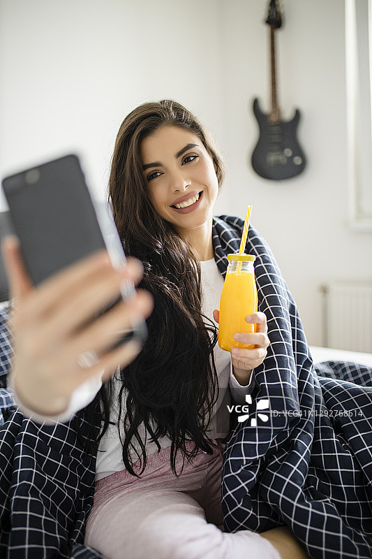 年轻女子在家休息时进行视频通话图片素材
