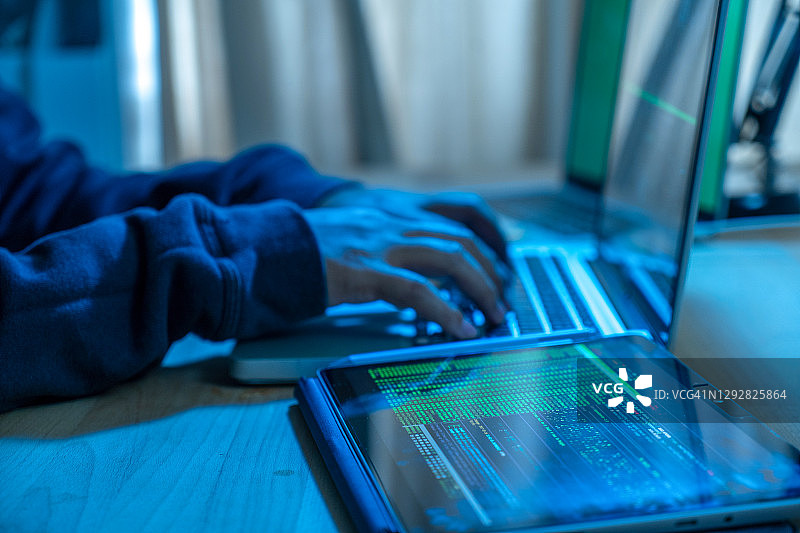 在笔记本电脑上打字的手部特写。夜间工作概念。图片素材