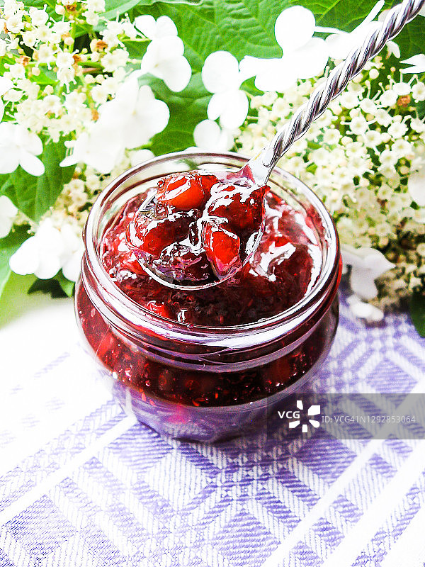 罐装蔓越莓酱或酱汁，以及一块涂有蔓越莓酱的早餐面包图片素材