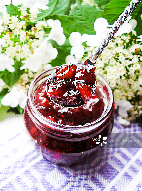 罐装蔓越莓酱或酱汁，以及一块涂有蔓越莓酱的早餐面包图片素材
