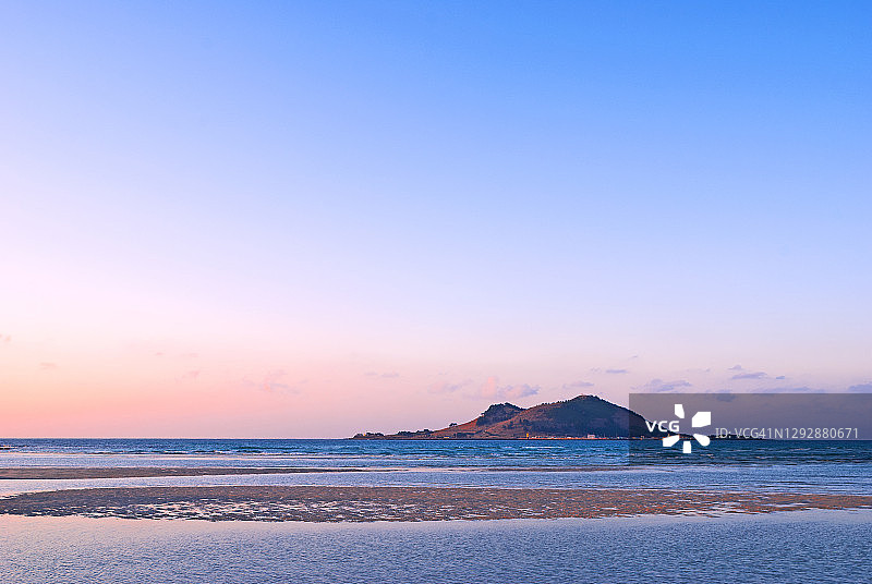 韩国济州岛金陵海滩和飞扬岛的日落景色图片素材