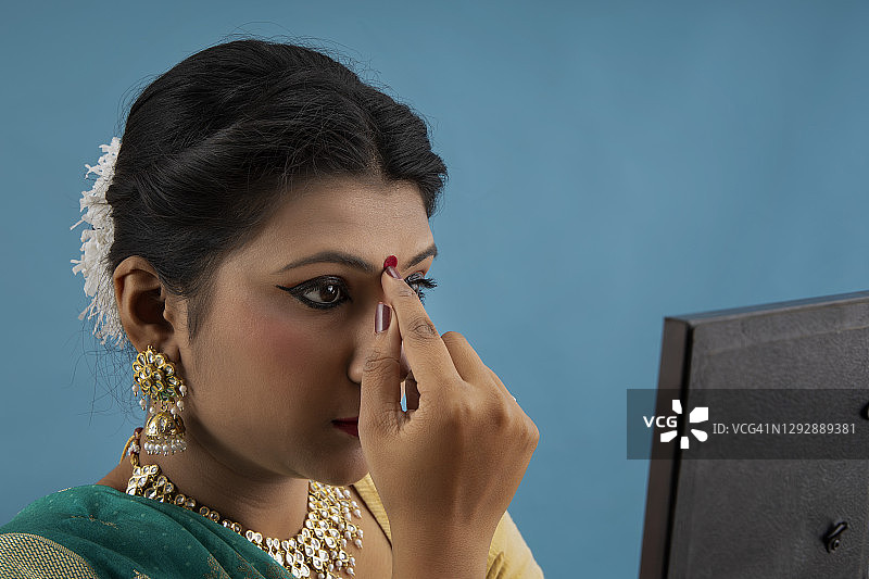 卡塔克舞者照镜，在前额点红点图片素材