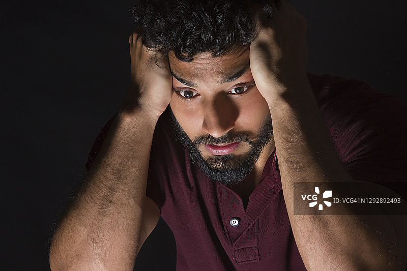 烦恼地抱着头的年轻男人图片素材