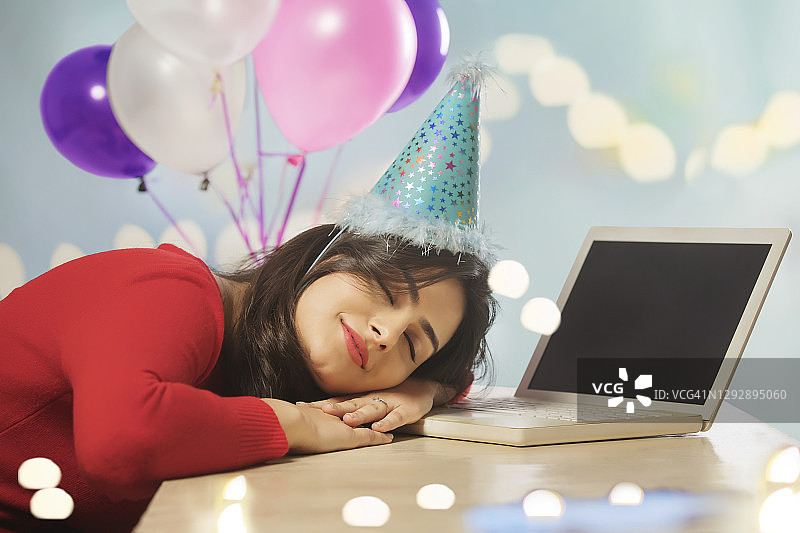 办公室聚会后在办公桌上睡着的年轻女人图片素材