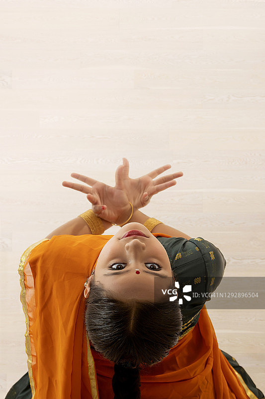 在纯色背景上表演的年轻印度古典舞者图片素材