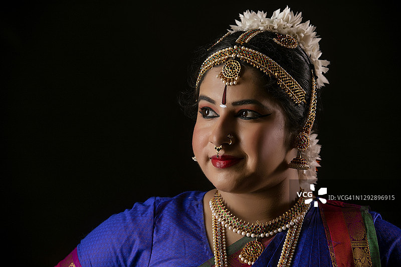 站在深色背景前美丽的婆罗多舞舞者图片素材