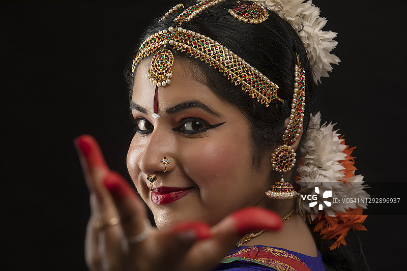 在黑暗背景前表演婆罗多舞的舞者图片素材