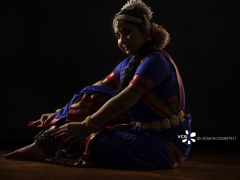 婆罗多舞舞者坐着系脚铃图片素材