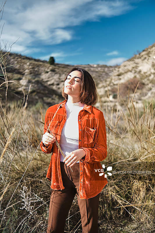 在山丘附近草地上的时尚女人图片素材