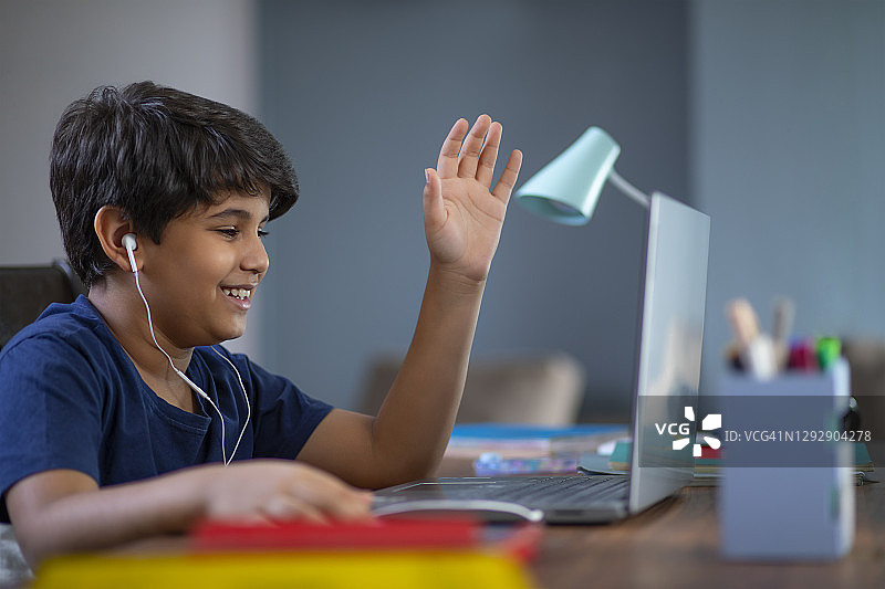 封锁期间用笔记本电脑上网课的男孩图片素材