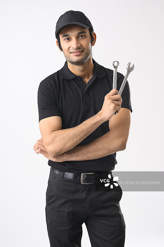 身穿制服，手握扳手的机修工图片素材