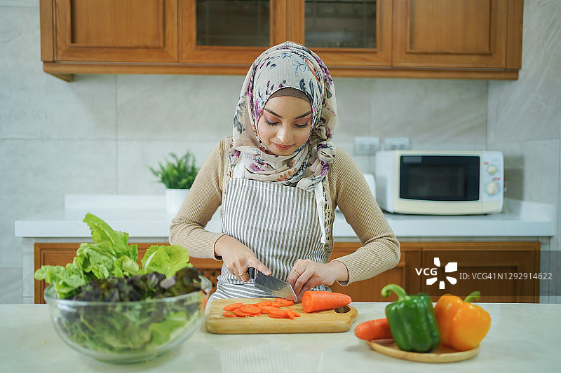 准备蔬菜的穆斯林妇女，居家烹饪的概念图片素材