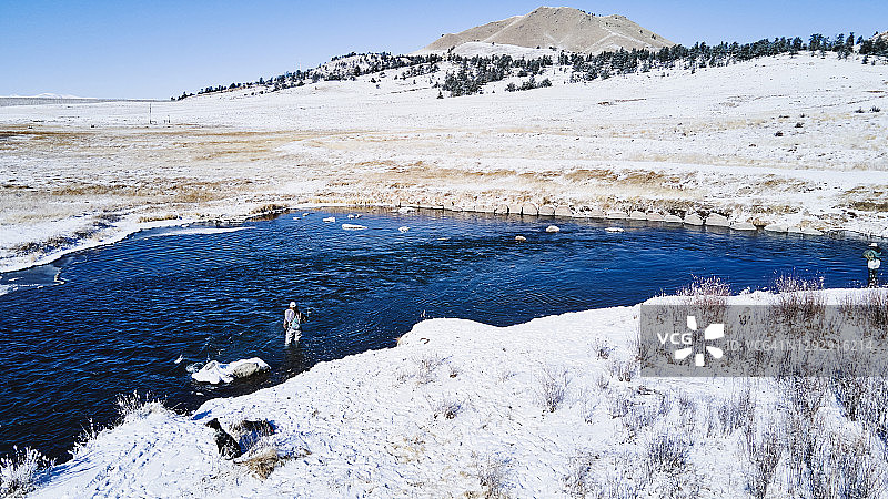 冬日清晨，女友们在山间溪流中飞蝇钓鱼鸟瞰图图片素材