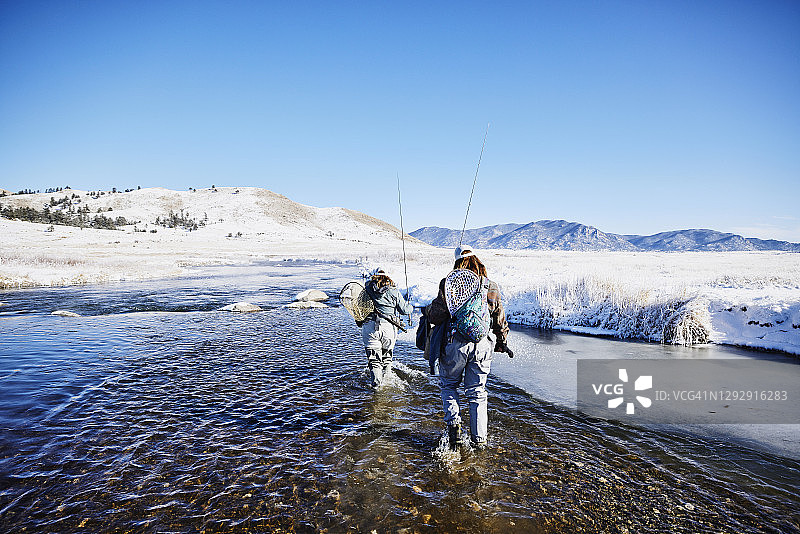 女人们在冬日清晨蹚过河流去飞蝇钓图片素材