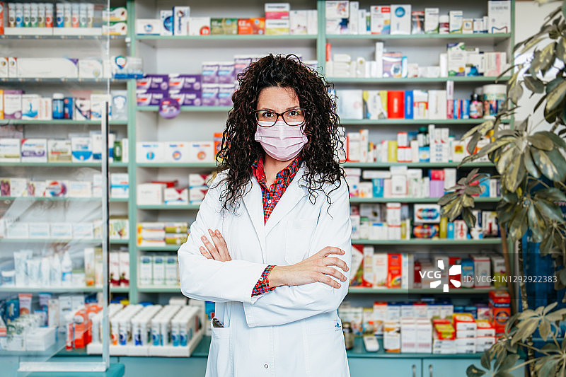 戴防护口罩的女药剂师在药房工作，医疗保健概念图片素材