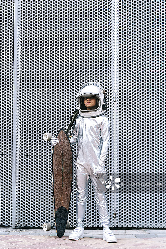 装扮成宇航员的孩子玩滑板图片素材