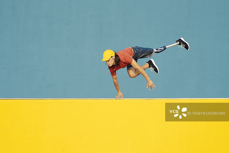 身患残疾的男人跃向彩色墙面图片素材