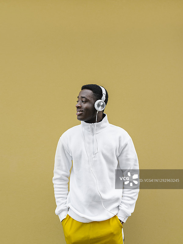 戴耳机听音乐的微笑青年人像图片素材