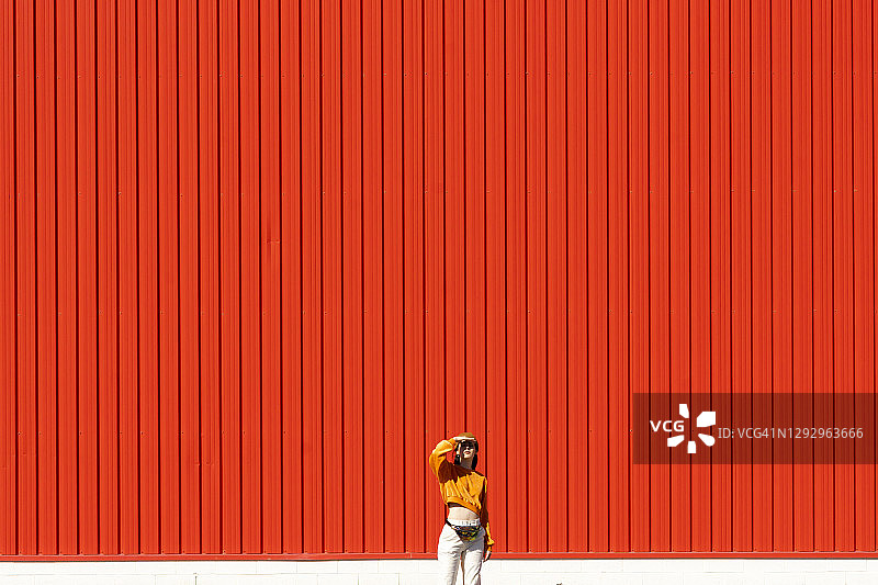 站在红墙前的年轻女人图片素材