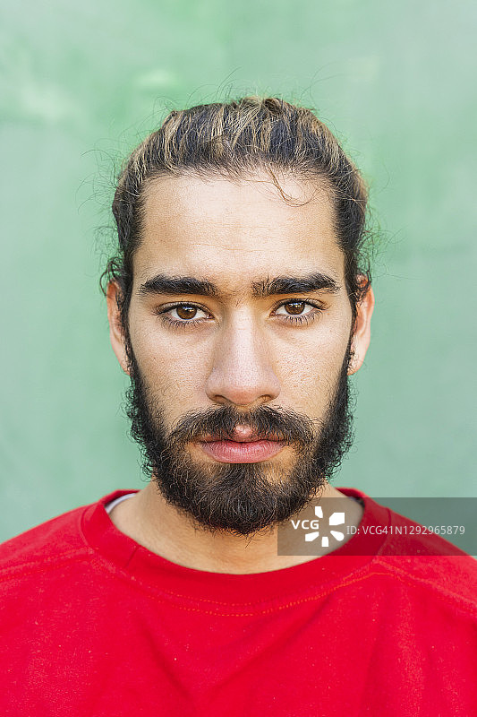 年轻的留胡子男人穿着红色卫衣图片素材