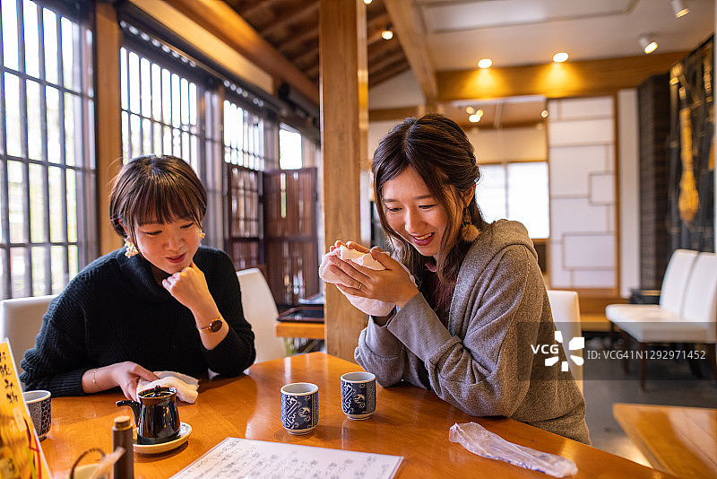 年轻女性朋友们在日本餐厅看菜单图片素材