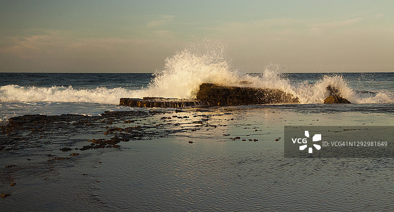 金色午后，阳光海岸岩石架上的海浪，澳大利亚昆士兰州图片素材