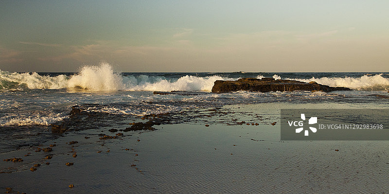 金色午后，阳光海岸岩石架上的海浪，澳大利亚昆士兰州图片素材