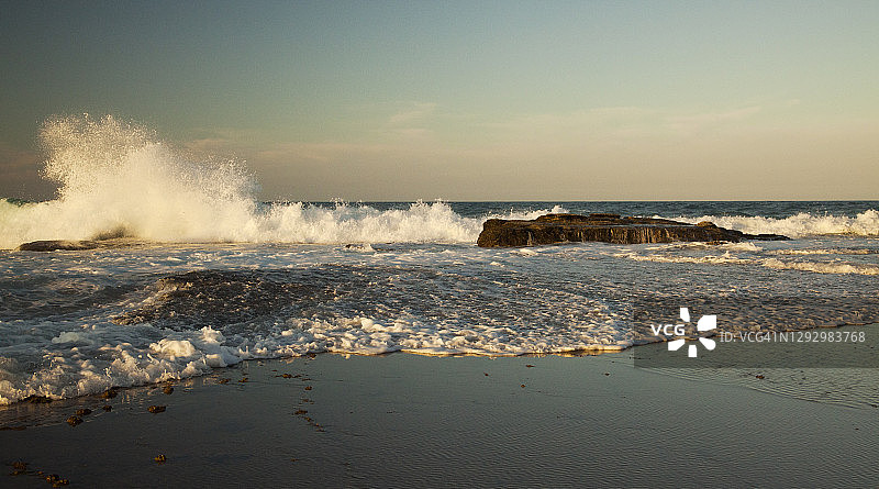 金色午后，阳光海岸岩石架上的海浪，澳大利亚昆士兰州图片素材