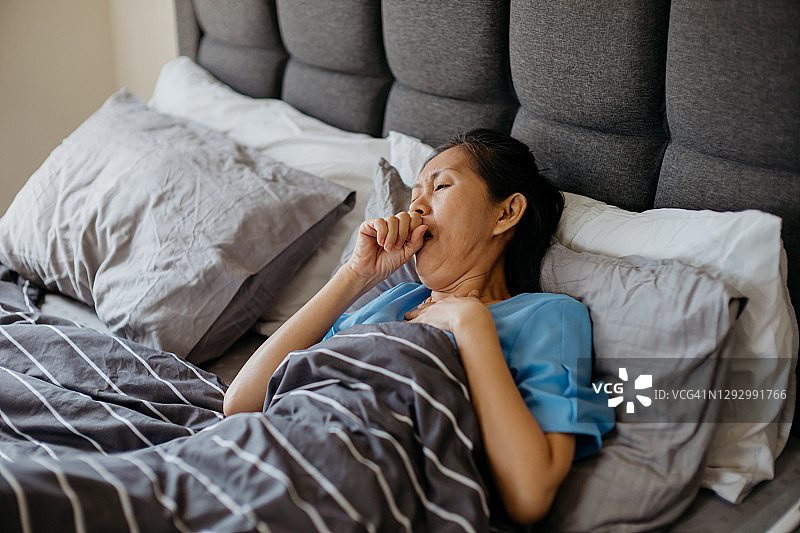 在床上咳嗽的亚洲老年妇女图片素材