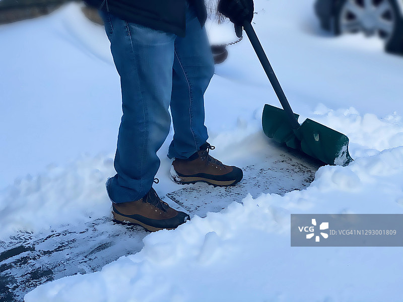 冬季风暴后，父亲铲雪为汽车开路图片素材