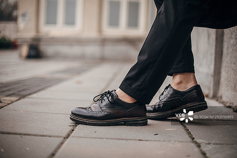 穿着皮鞋走在街上的时尚男人图片素材