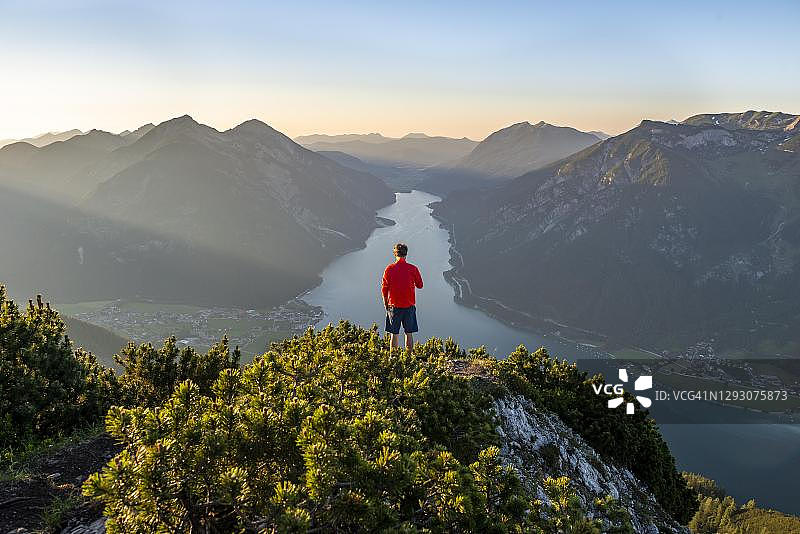 登山者眺望山景，在Baerenkopf山顶的山松，可看到阿亨湖日落景色，左侧是Seekarspitze和Seebergspitze山图片素材