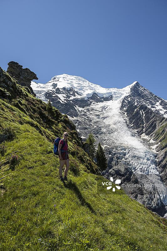 在冰川前徒步的徒步者,徒步路线是La Jonction,冰川是塔孔纳兹冰川,勃朗峰和比奥纳赛针峰的山顶,右边是勃朗峰,霞慕尼,上萨瓦省,法国图片素材