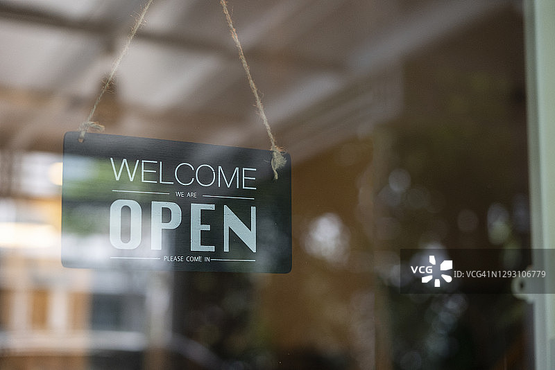 咖啡馆入口门上悬挂的营业中标志图片素材