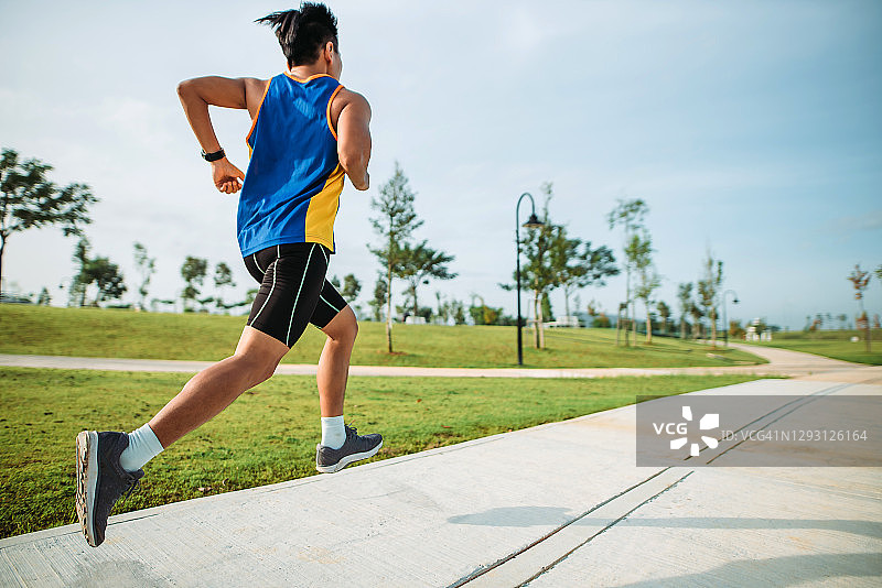 周末早晨在公园跑步的华人男子图片素材