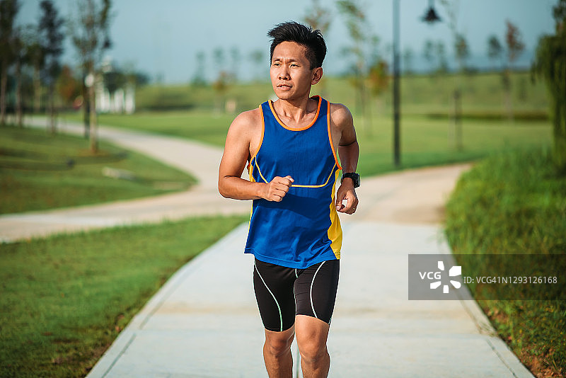 周末早晨在公园跑步的华人男子图片素材