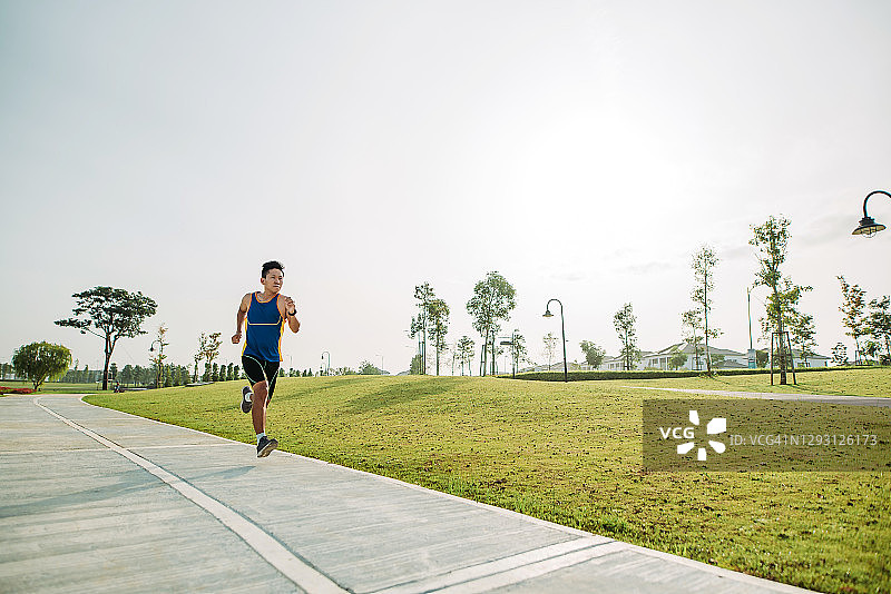 周末早晨在公园跑步的华人男子图片素材