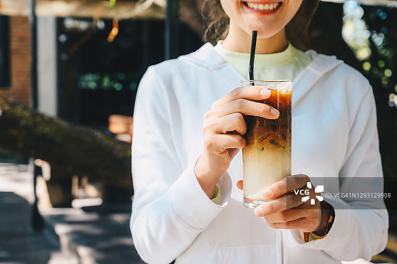 快乐女人手捧冰牛奶咖啡特写镜头图片素材